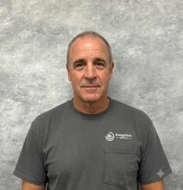 Terry Jandree, Business Solutions Coordinator at EnergiTech Services, wearing a gray company shirt against a neutral studio backdrop.